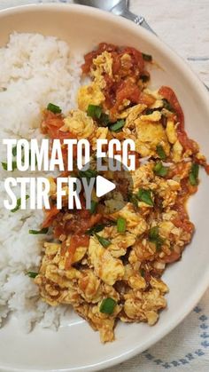 a white plate topped with rice and meat covered in tomato sauce next to a fork