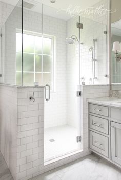 a bathroom with white tile and marble counter tops