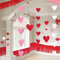 red and pink hearts hanging from the ceiling in a room with white trimmings