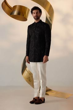 Editor's Note Showcasing our new long bandhgala silhouette in black color. Hand embroidered with tone-on-tone, bluish-gray, and gold threads in an abstract manner all-over. Paired with ivory tapered trousers. Fabric: Linen silk Color: Black, ivory Components: Bandhgala and trousers Occasion: Wedding guest Fit: Regular Note: Product colour may slightly vary due to photographic lighting sources Care: Dry clean only About the Designer After establishing himself as the leading couturier in the indus Parisian Night, Blouse Yoke, Dhoti Pants, Haldi Ceremony, Royal Look, Indian Man, Bluish Gray, Tapered Trousers, Indian Wedding Outfits