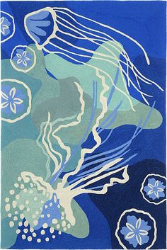 a blue and white rug with jellyfishs on the bottom, in front of an ocean background