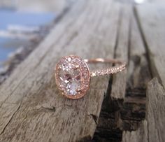 a close up of a diamond ring on a wooden surface with water in the background