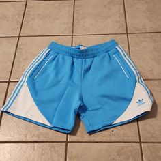 Shorts Originals Sky Rush / White 70% Cotton 30% Polyester ( Recycled) Sporty Light Blue Shorts With Pockets, Blue Shorts With Three Stripes For Summer, Blue Bermuda Athletic Shorts, Blue Bermuda Casual Athletic Shorts, Mens Red Shorts, Yellow Adidas, Adidas Skateboarding, Basketball Clothes, Adidas Brand