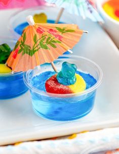 there is a small bowl with jelly bears in it and an umbrella on the table