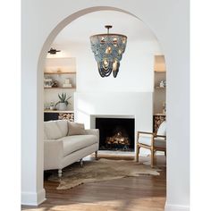 a living room filled with furniture and a fire place under a chandelier hanging from the ceiling