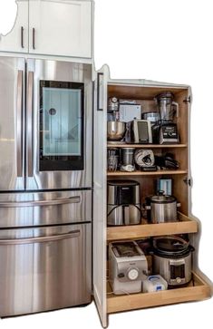 an open refrigerator next to a shelf with pots and pans on it's sides