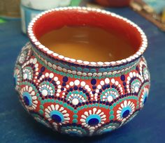 a colorful vase filled with liquid sitting on top of a blue tablecloth covered table