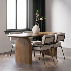 a vase with flowers on top of a table next to two chairs and a window