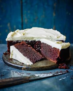 a cake with white frosting on it sitting on top of a metal platter