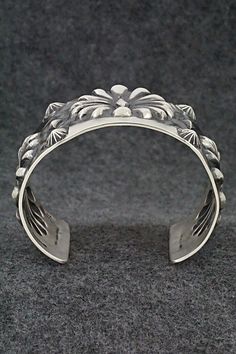 This stunning sterling silver bracelet was made by Navajo silversmith Elvira Bill. The inside is signed Elvira Bill and stamped sterling.Size: 5 7/8" (will fit up to a 7 1/4" wrist)Gap: 1 3/8"Width: 2"Free shipping on all orders! We ship with USPS and always include tracking. All orders ship within a day of payment.Returns are accepted up to 30 days after you receive your order. Just send us a message. Our shop offers cash back or store credit. The item must be returned in new condition. Southwestern Style Silver Round Cuff Bracelet, Silver Southwestern Style Bracelet With Oyster Clasp, Silver Southwestern Style Oyster Bracelet, Southwestern Style Silver Oyster Bracelet, Southwestern Silver Cuff Bracelet With Oyster Detail, Sterling Silver Bracelet, Sterling Silver Bracelets, Silver Bracelet, Gap