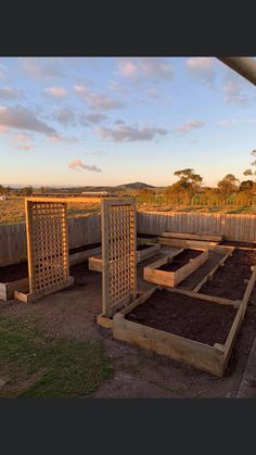 an outdoor garden area with raised wooden planters and trelliss on the ground