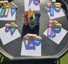 the table is set up with paper cutouts and colored pencils on it,