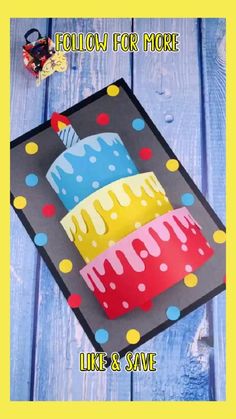 a birthday cake made out of paper on top of a blue wooden background with the words follow for more like & save