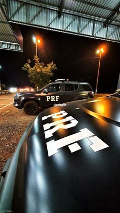 two police cars parked next to each other in a parking lot at night with lights on