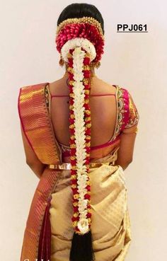 the back of a woman's head is adorned with braids and beads,