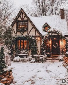 a house covered in snow with wreaths and lights