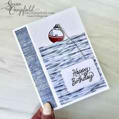 someone holding up a birthday card with a boat on it