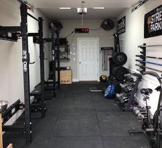 a home gym with various equipment in the room and on the wall, there is a door that leads to another room