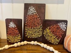 two wooden blocks with string art on them