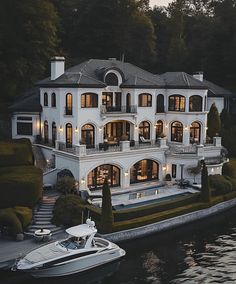 a large white house sitting on top of a lake