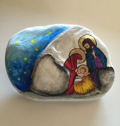 a painted rock depicting the birth of jesus