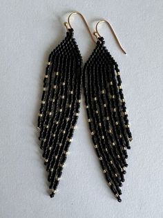 black and gold beaded earrings on white background