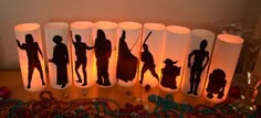 several candles with silhouettes of people on them