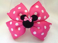 a pink minnie mouse hair bow with white polka dots