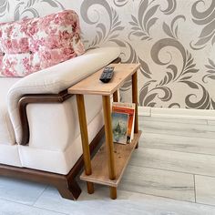 a white couch sitting next to a wooden table on top of a hard wood floor