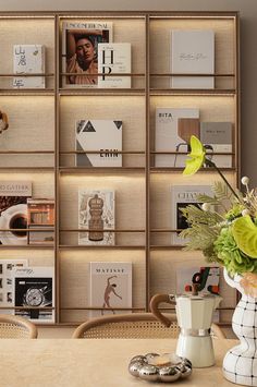 a wooden table topped with vases filled with flowers and books next to a book shelf