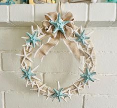 a starfish wreath hanging on a brick wall