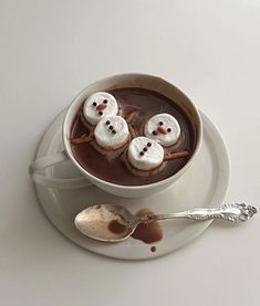 a cup of hot chocolate with marshmallows in the shape of snowmen