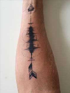 a person's arm with an arrow tattoo on the left side of their body