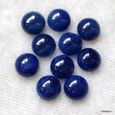 six blue marbles sitting on top of a white cloth