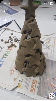 a clay christmas tree sitting on top of a table next to scissors and other crafting supplies