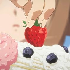 someone is picking up a strawberry on top of a piece of cake with blueberries