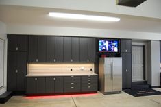 a kitchen with cabinets and a television on the wall