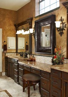 a large bathroom with marble counter tops and brown cabinets