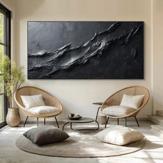 a living room with two chairs and a large black painting on the wall above them