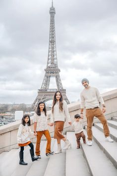 a family poses in front of the eiffel tower