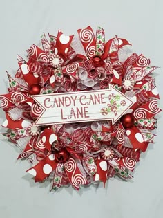 a candy cane wreath is hanging on the wall next to a sign that says candy cane lane