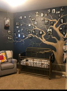 a baby's room with a tree painted on the wall and a crib