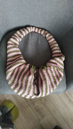 a knitted bag sitting on top of a gray chair