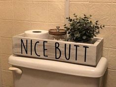 a toilet with a wooden sign that says nice but