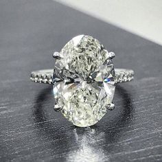 an oval cut diamond ring on a table