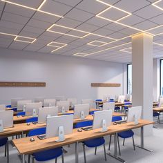 an empty classroom with desks and laptops in it's center area,