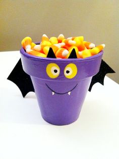 a purple bucket filled with candy bats sitting on top of a white table next to a wall