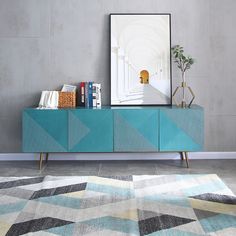 a blue sideboard sitting on top of a rug next to a painting