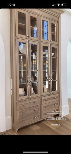 a large wooden cabinet with glass doors and drawers