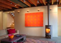 an image of a living room with a fire place in the center and pictures on the wall